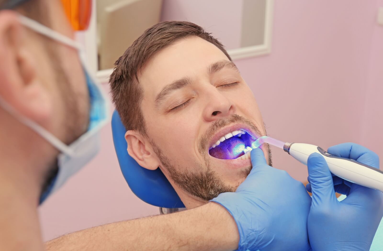A dentist uses a UV light to harden a filling and fix a cracked tooth.