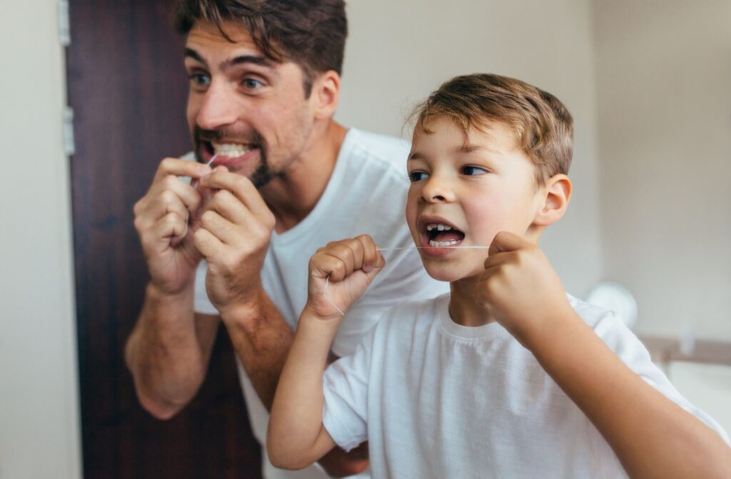 A father and son flossing their teeth