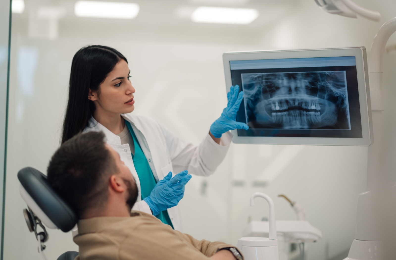 A patient and dentist looking at a dental x-ray