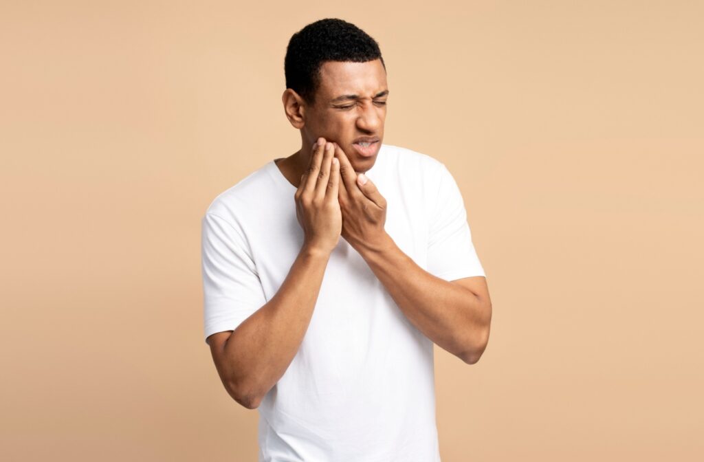 A person holding their jaw from cavity pain in their mouth